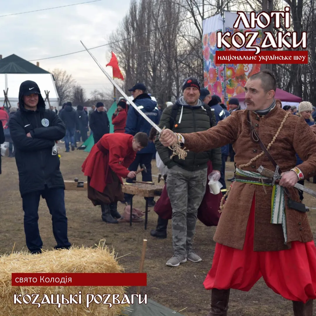 Козак показує гостям шаблю на святі Колодія